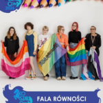 Opis ogólny Zdjęcie jest plakatem lub oficjalną fotografią z wydarzenia, utrzymaną w jasnej tonacji. Przedstawia grupę sześciu młodych osób stojących obok siebie na białym tle. Wszyscy są uśmiechnięci lub patrzą w obiektyw z powagą, trzymając różne flagi społeczności LGBTQ+. Kompozycja i grafika Zdjęcie jest skomponowane pionowo. Na samej górze znajduje się pasmo kolorowych kredek ułożonych w tęczę, od fioletu do różu. W lewym górnym rogu, na niebieskim tle w kształcie plamy, umieszczone jest białe logo przedstawiające sylwetkę kucyka z napisem „KOSZAŁ CON 2026”. Opis osób i flag (od lewej do prawej) Uczestnicy zdjęcia stoją ramię w ramię, a flagi, które trzymają, są częściowo rozłożone przed nimi, tworząc barwny ciąg. Pierwsza osoba od lewej: Młoda kobieta o długich, brązowych włosach, ubrana w czarną bluzę. Trzyma flagę lesbijską (odcienie pomarańczowego i różowego). Druga osoba: Młoda kobieta z kręconymi włosami, ubrana w błękitny, dżinsowy kombinezon z kolorowym paskiem i tęczowe trampki. Trzyma flagę lesbijską. Trzecia osoba: Młoda osoba z krótkimi, jasnymi włosami, ubrana w biały T-shirt z czarnym nadrukiem. Trzyma centralną flagę w pastelowych kolorach (żółty, różowy, fioletowy, zielony). Na tej fladze znajduje się wyraźny napis w języku polskim: „FALA RÓWNOŚCI” oraz mniejszy napis „FUNDACJA”. Czwarta osoba: Młoda kobieta w okularach i pomarańczowej bluzce z koronką. Trzyma tę samą flagę co osoba trzecia oraz kolejną – tradycyjną tęczową flagę (Gay Pride). Piąta osoba: Młoda osoba z włosami zafarbowanymi na jasnoczerwono/różowo, w okularach, ubrana w czarny golf i dżinsy. Trzyma tęczową flagę. Szósta osoba: Osoba z krótkimi, czarnymi włosami, w okularach i czarnej bluzie. Trzyma flagę aseksualną (fioletowy, biały, czarny, szary), a za nią widać też fragment flagi transseksualnej (niebiesko-różowy). Dół zdjęcia i napisy U dołu zdjęcia znajduje się szeroki, granatowy pasek przypominający rozlaną farbę. Po lewej stronie tego paska powtórzone jest jasnoniebieskie logo „KOSZAŁ CON” z kucykiem. Po prawej stronie, obok logo, widnieje duży, biały napis kapitalikami: „FALA RÓWNOŚCI”. Zdjęcie ma pozytywny, inkluzywny wydźwięk, pokazując solidarność i dumę osób reprezentujących różne tożsamości.